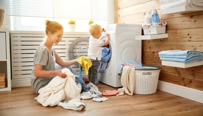 Toddler helping his mom with laundry as part of toddler chores