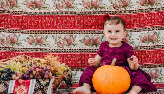 Armenian baby girl sitting with a pumpkin