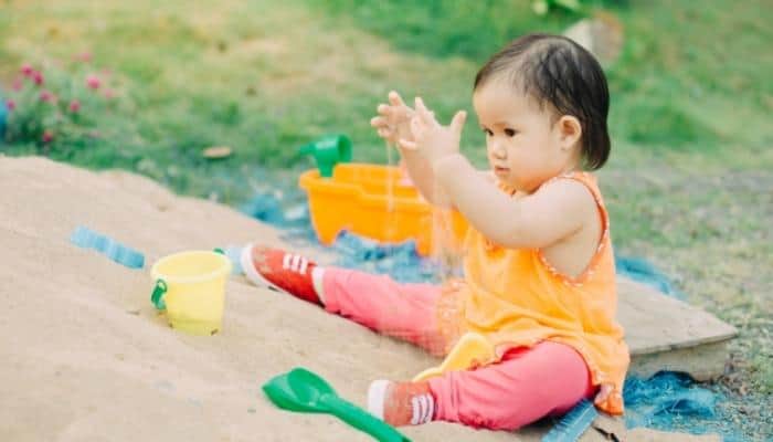 a baby sensory playing in the sand