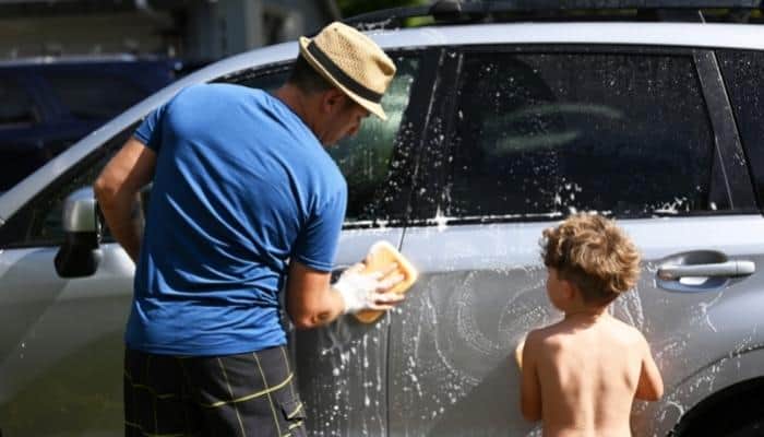father and son washing the car as a free father's day gift