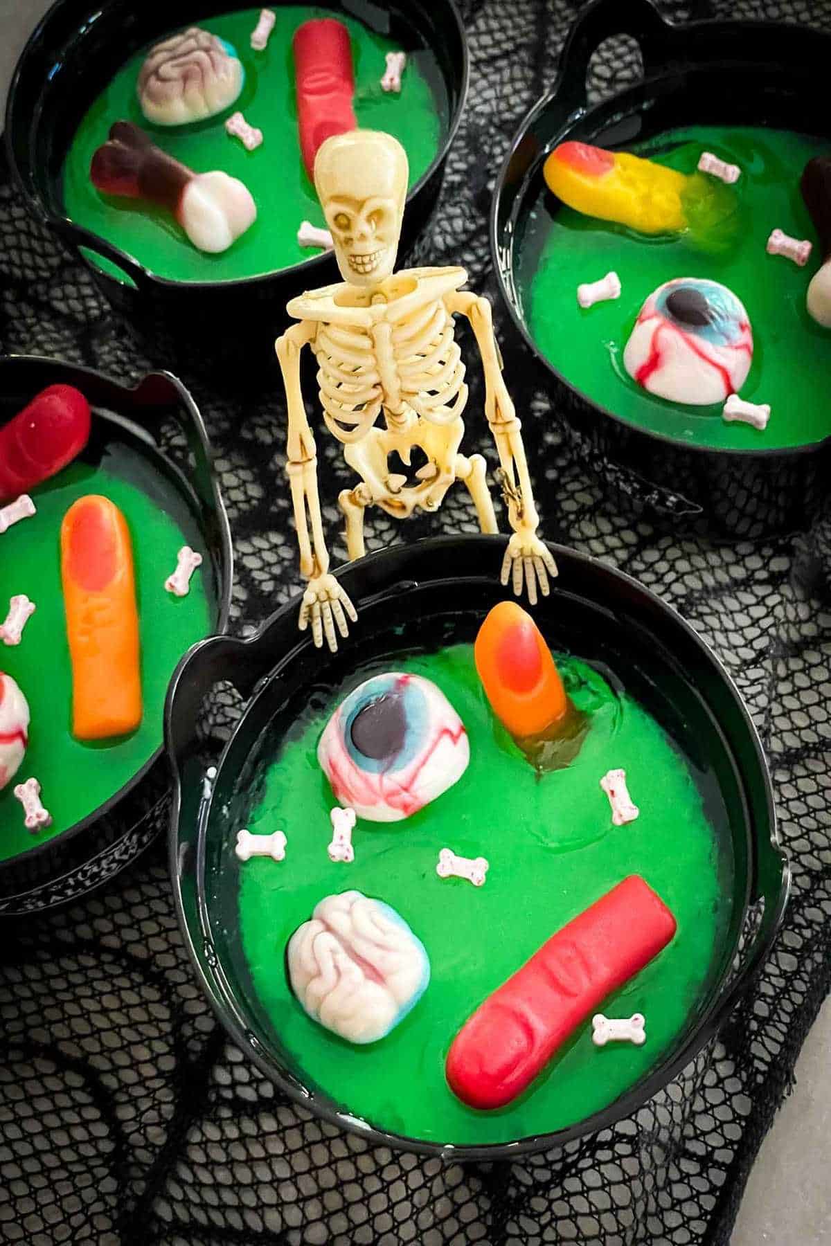 A bewitching display of spooky bowls filled with both skeletons and candy, perfect for Hocus Pocus snack ideas.