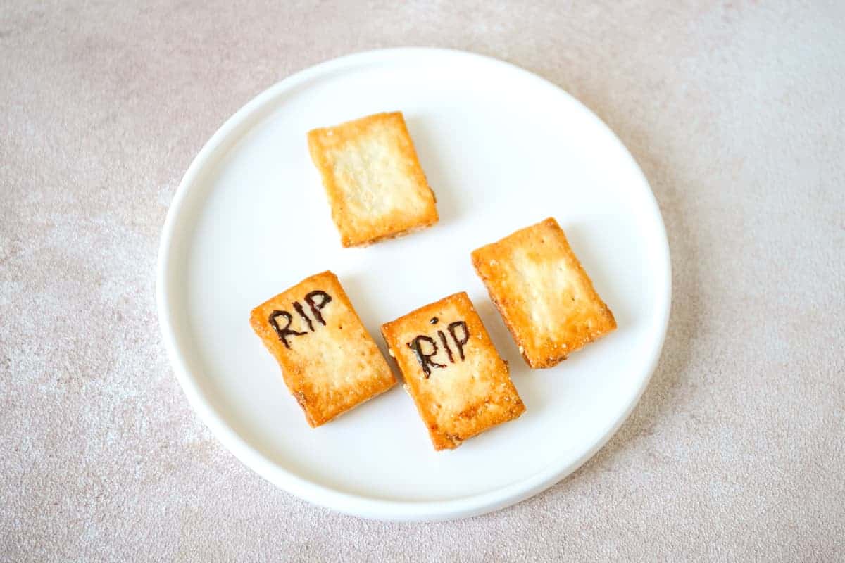Graveyard-inspired cookies with the word "rip" written on two out of 4 pieces.