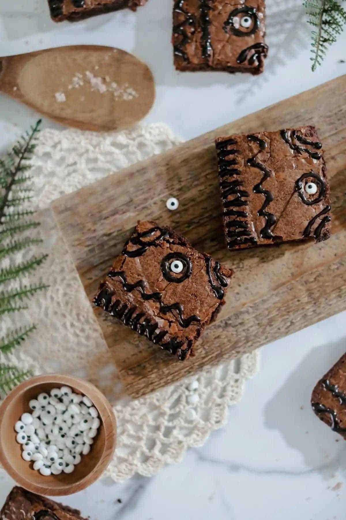 A wooden cutting board with hocus pocus inspired brownies on it.