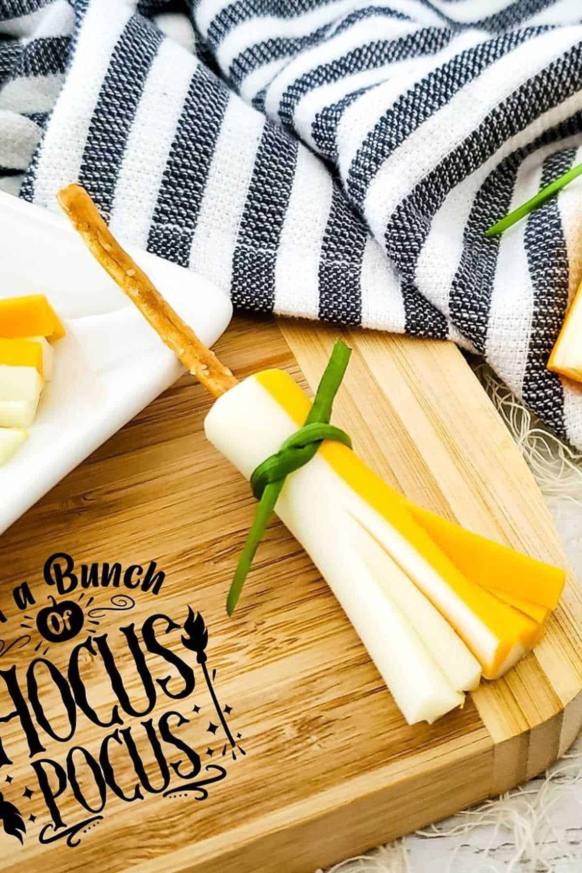 A cheese stick broomstick on a cutting board.