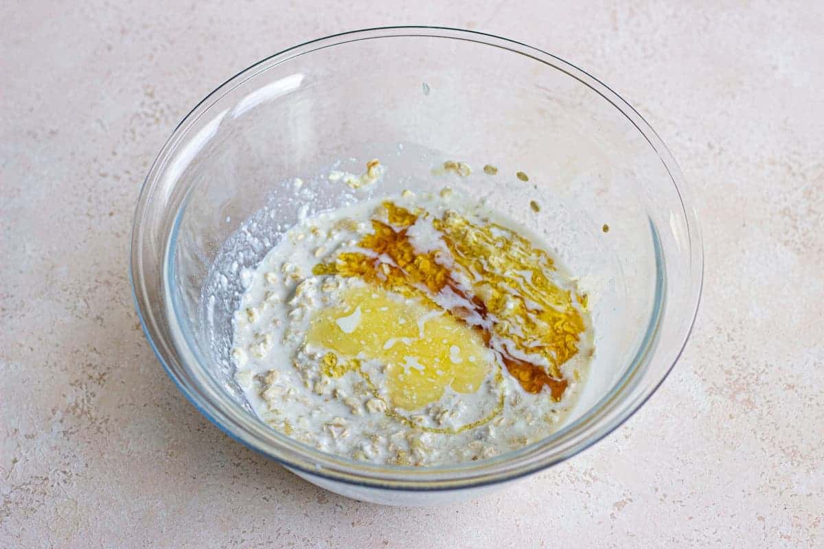 A glass bowl with wet ingredients in it.