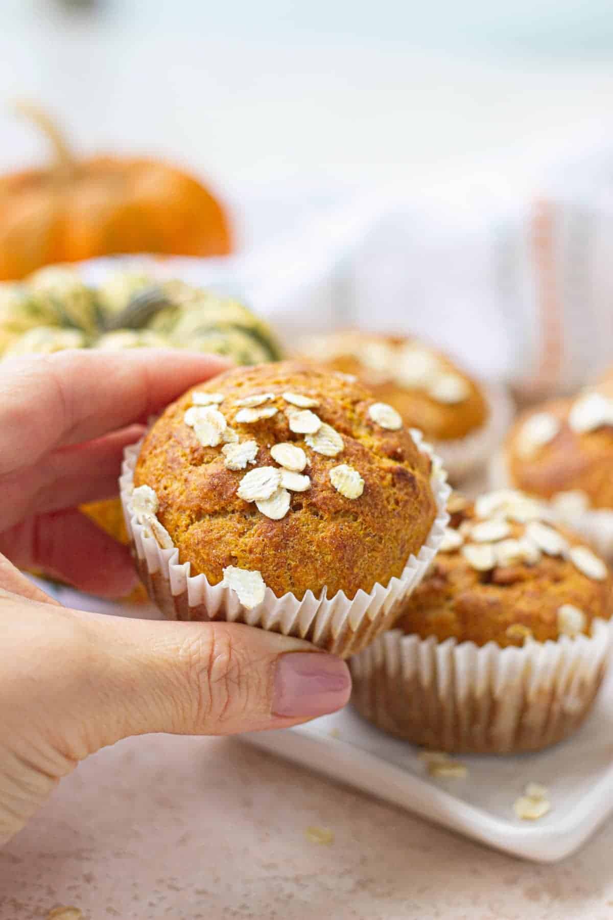 Pumpkin muffins with oats on a white plate.