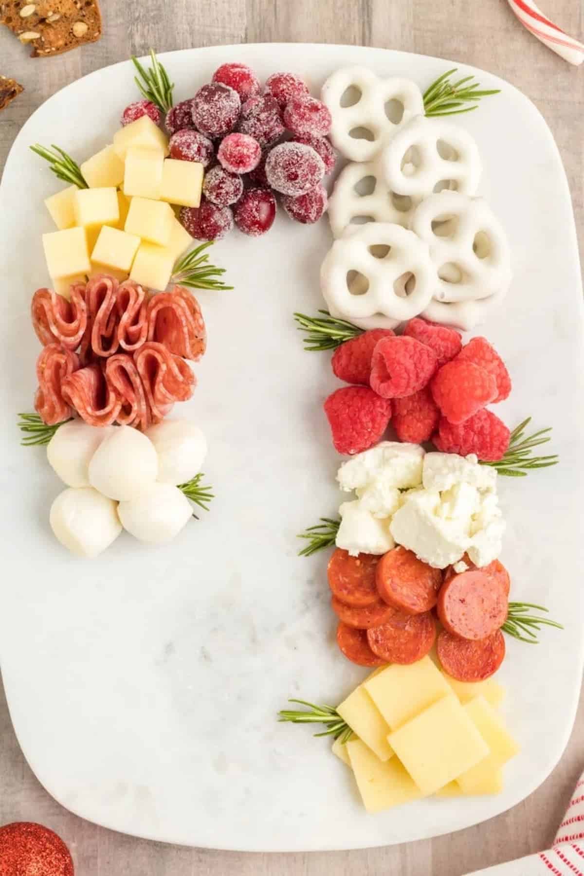 A platter of cheese, crackers, fruits and meats.