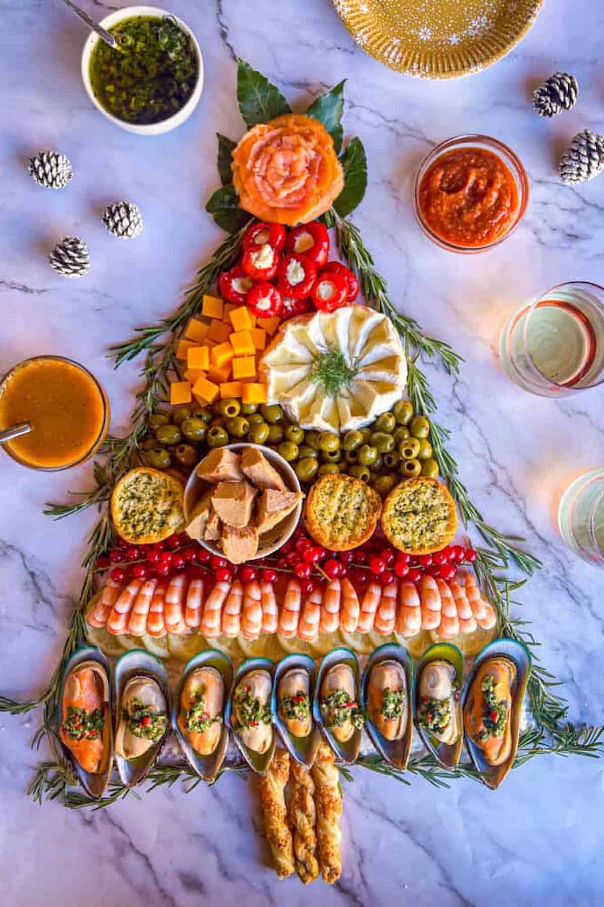 A Christmas tree made out of seafoods, olives, and cheese.