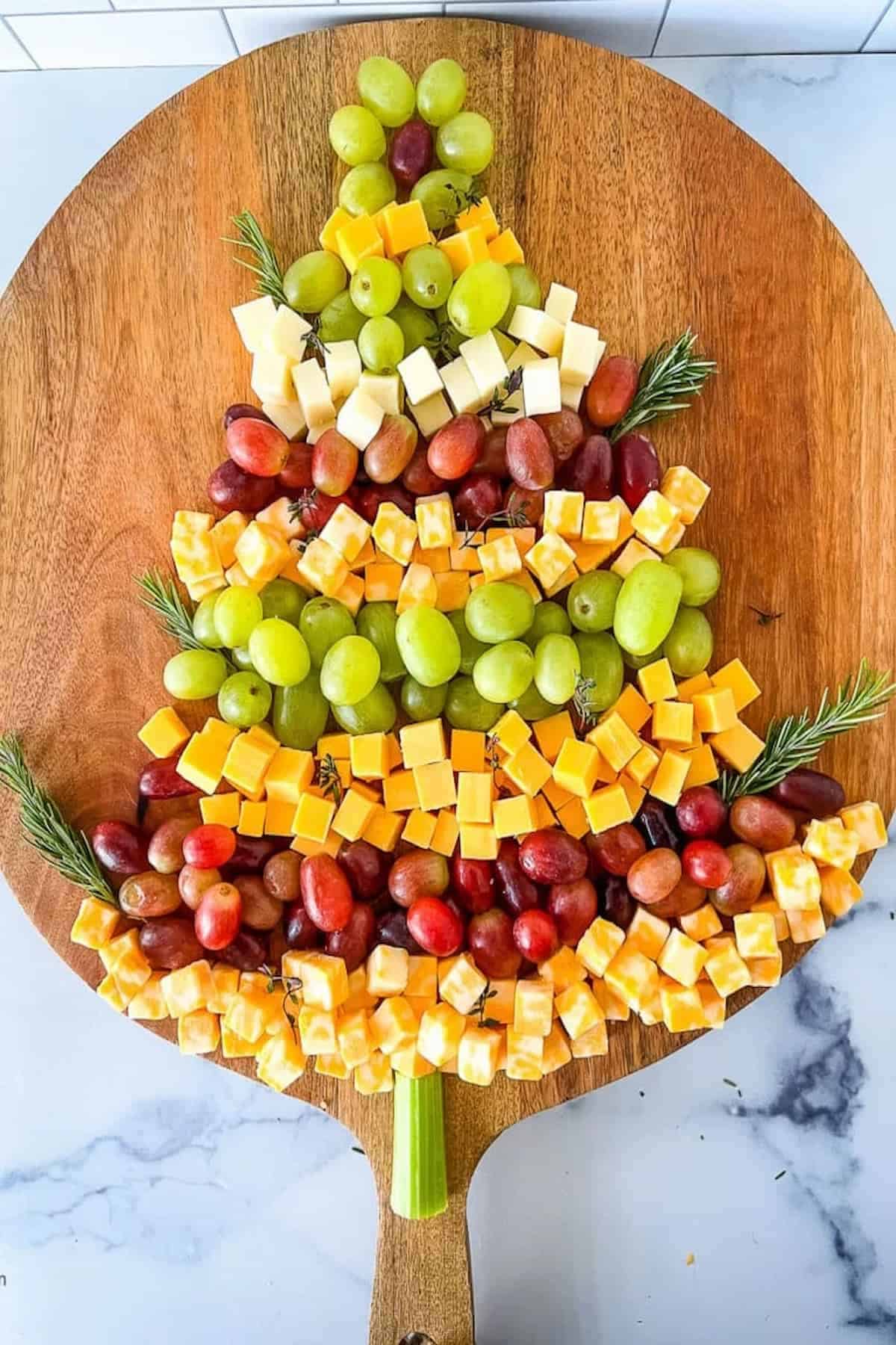 A Christmas tree made out of cheese and grapes.