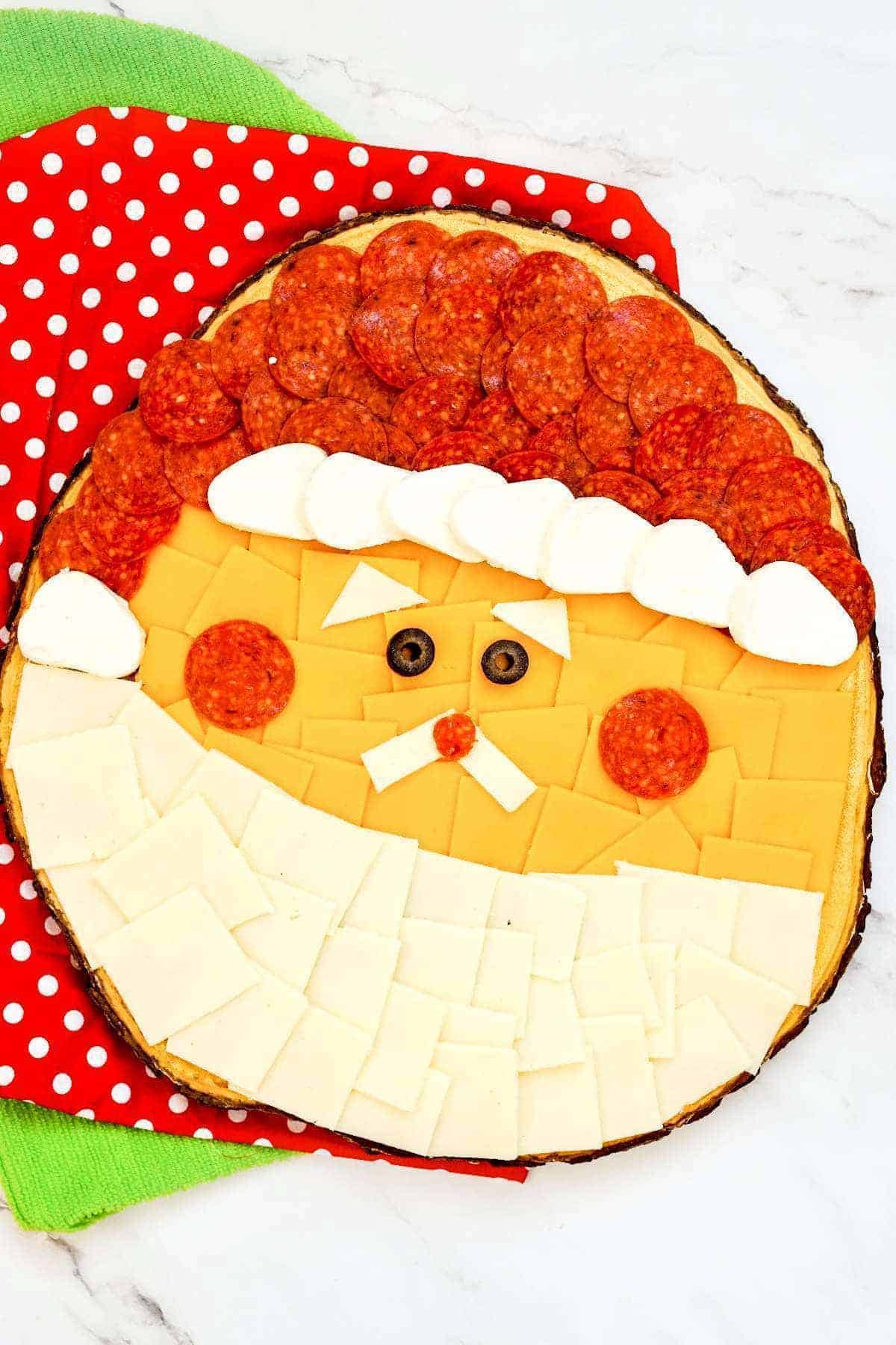 A Santa Claus face made out of pepperoni and cheese.