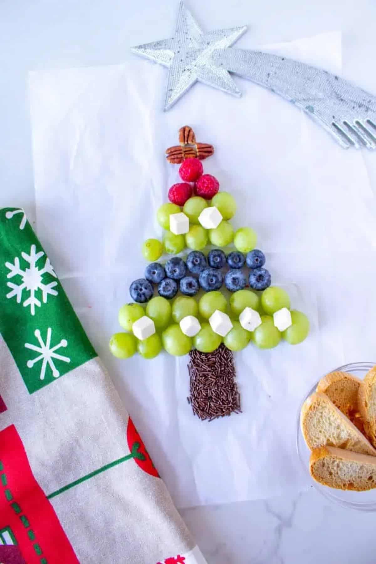 A Christmas tree made of grapes and blueberries.