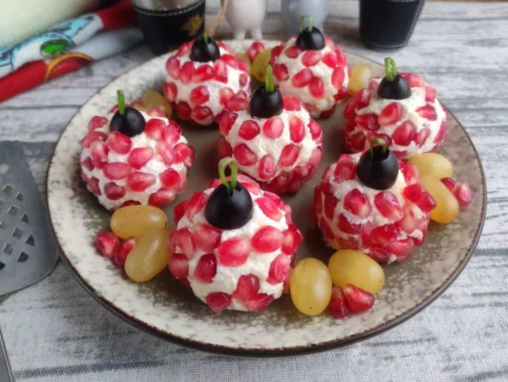 Festive cheese balls with pomegranate on a plate.