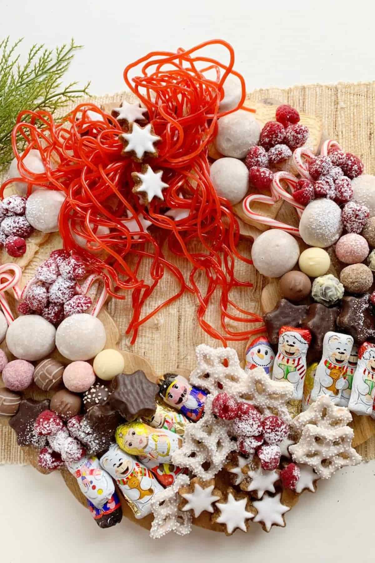A Christmas wreath charcuterie board decorated with festive candies.