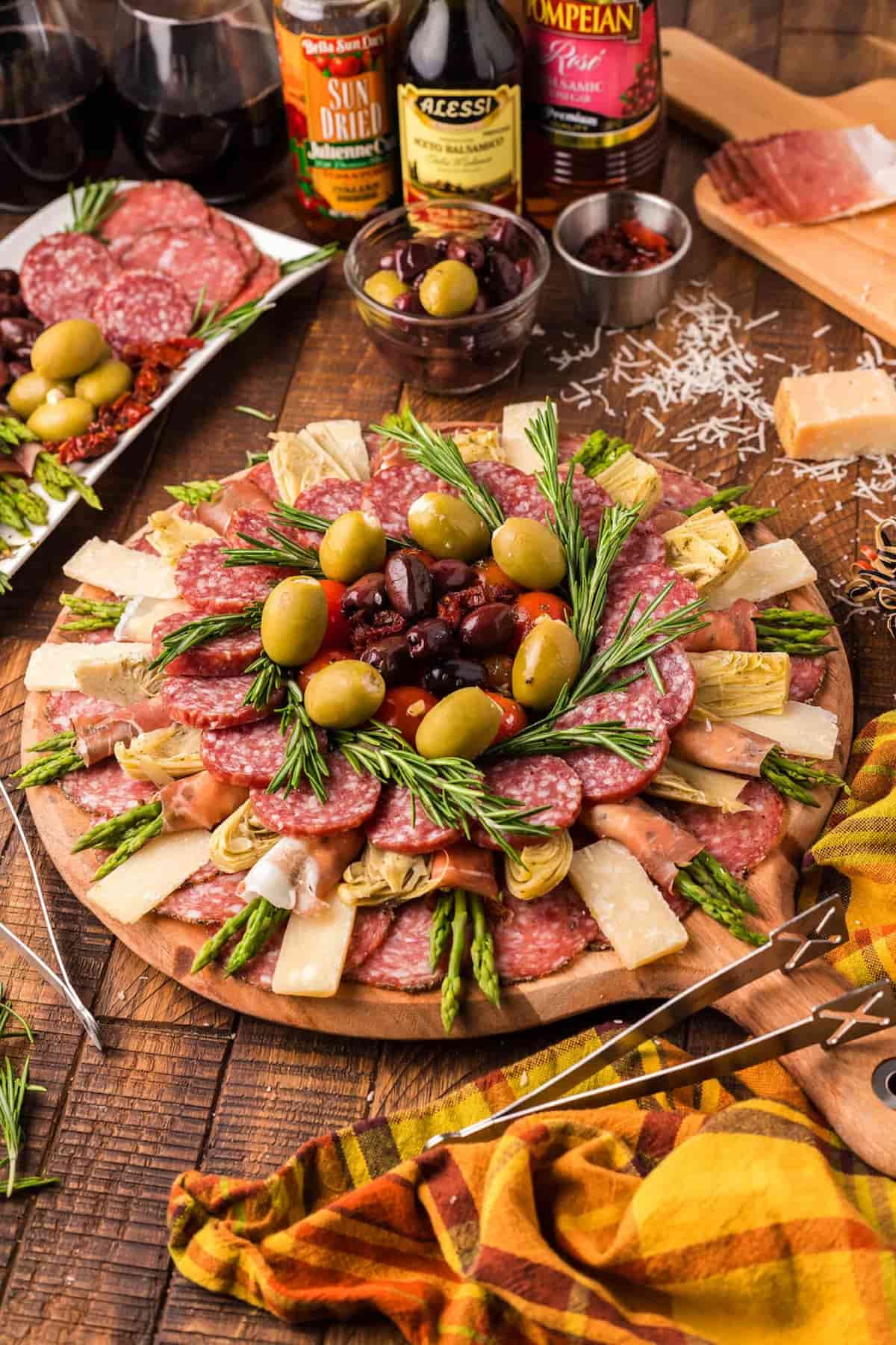 A platter of meats, cheeses, and olives on a wooden table.