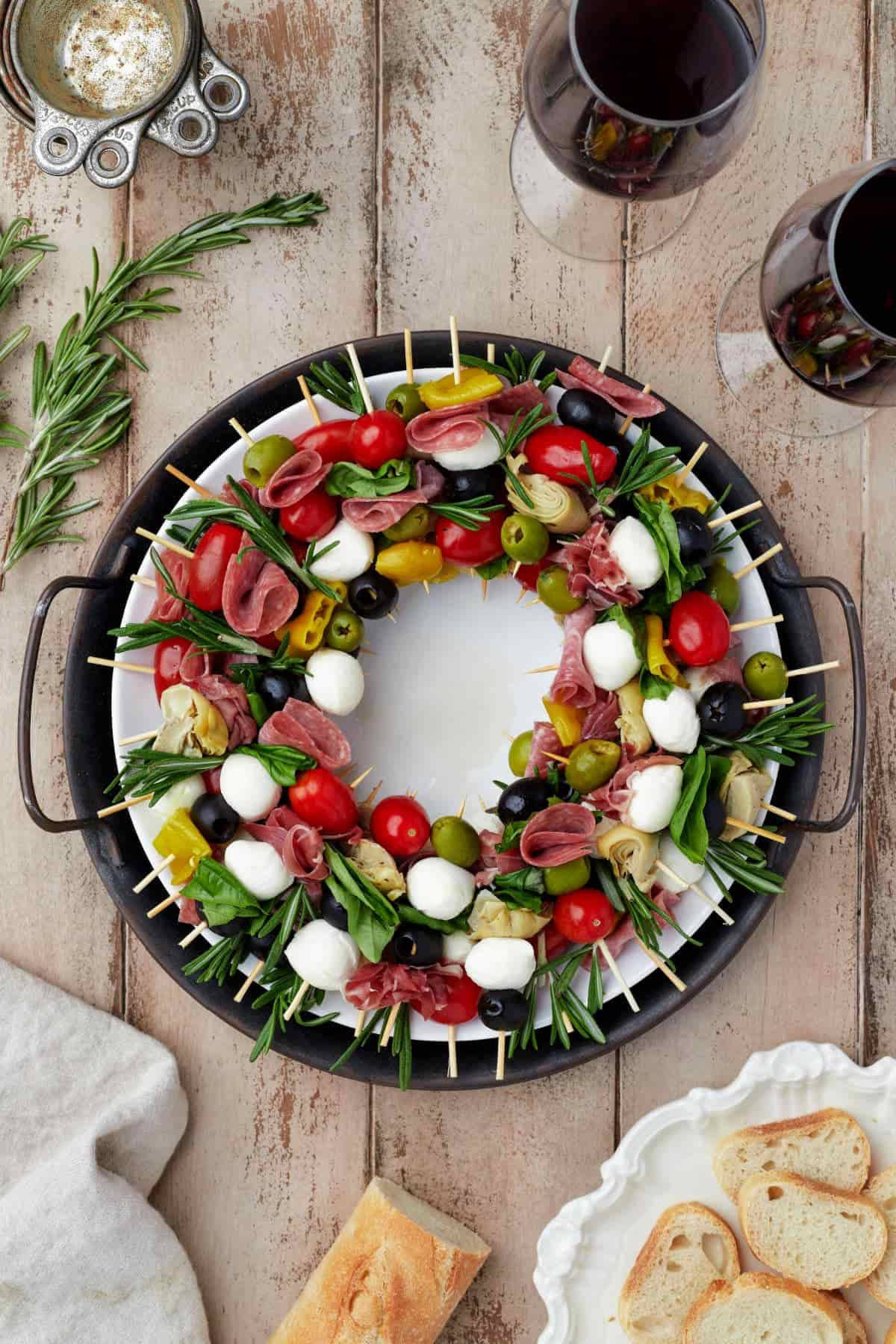 A platter with skewers of meat, cheese, fruits.