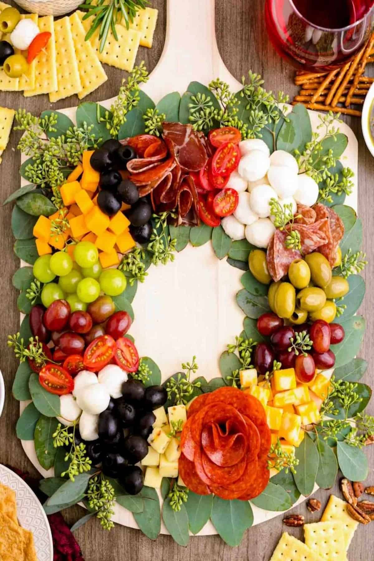A charcuterie wreath made out of cheese, meat. and fruits.