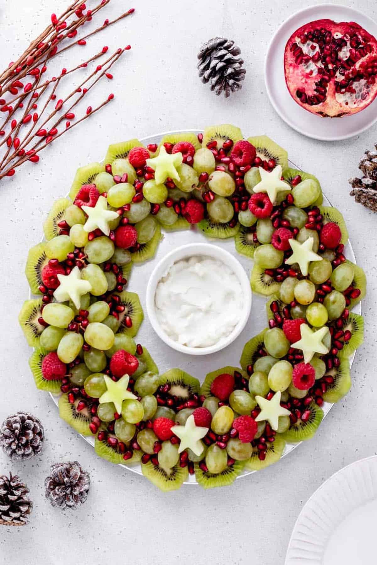 A wreath of fruit and pomegranate on a plate.