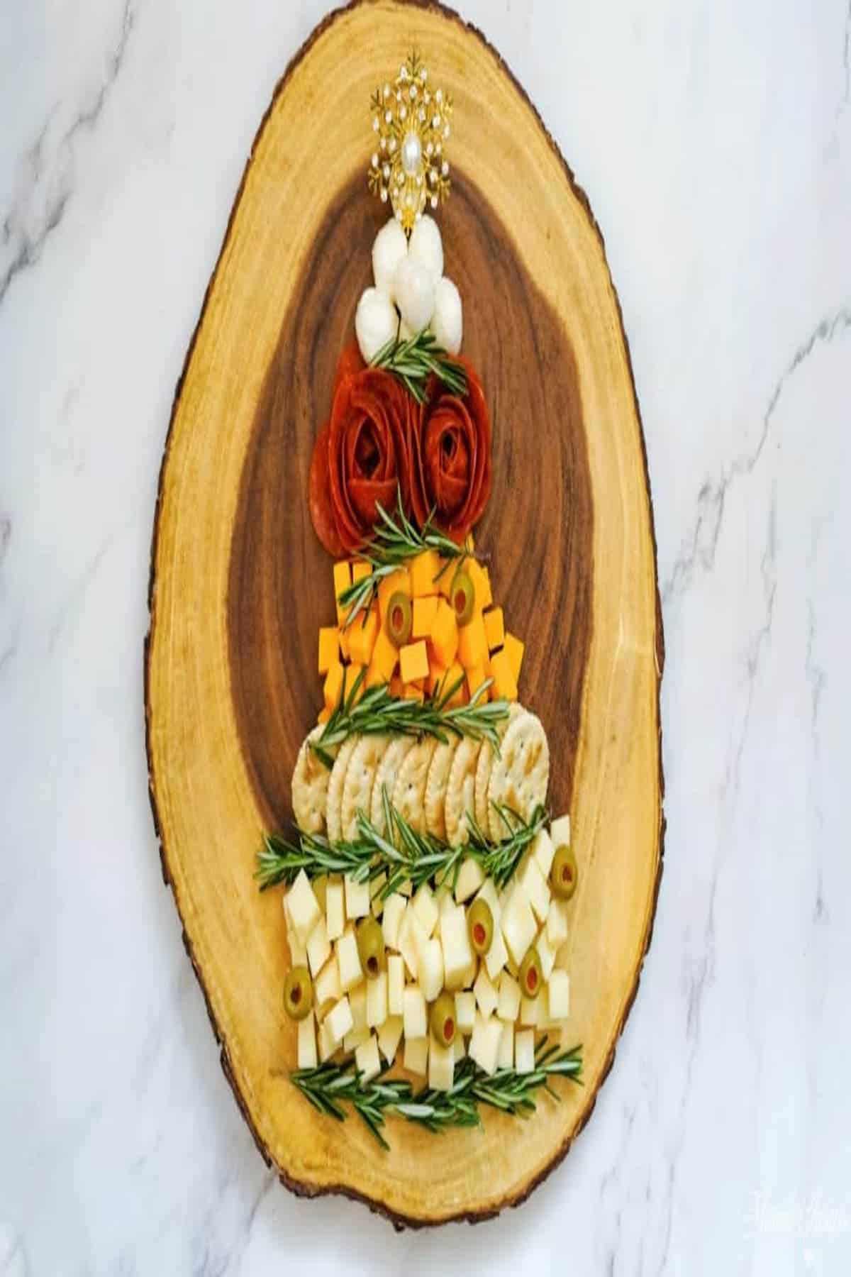 A Christmas tree charcuterie board made out of cheeses and meats.