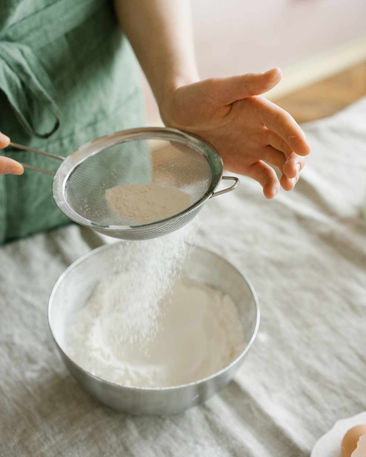 A woman sifting baking powder.