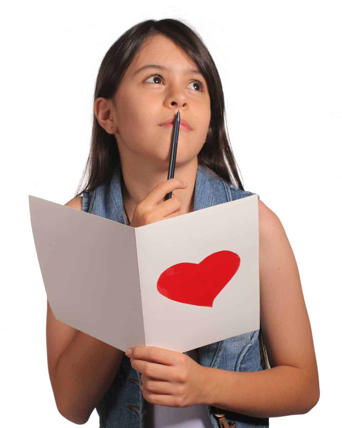A girl holding a paper with a heart on it.