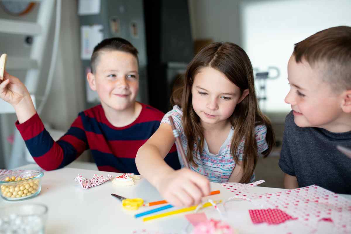 A group of kids are playing Valentine's Day game for kids at a table.