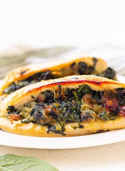 A white plate with a chicken stuffed with spinach and dates.
