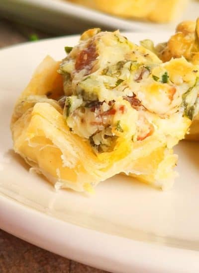 A plate of mini cheese and spinach tartlets.