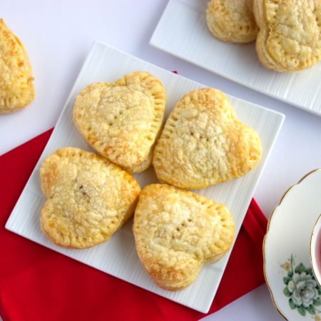 Four heart-shaped cherry hand pies desserts for Valentine's day.