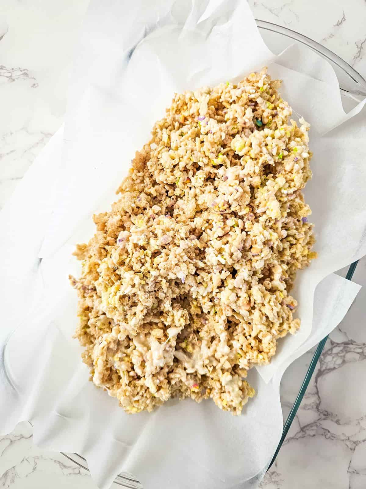 Rice crispy cereal mixture on a pan with a baking sheet.
