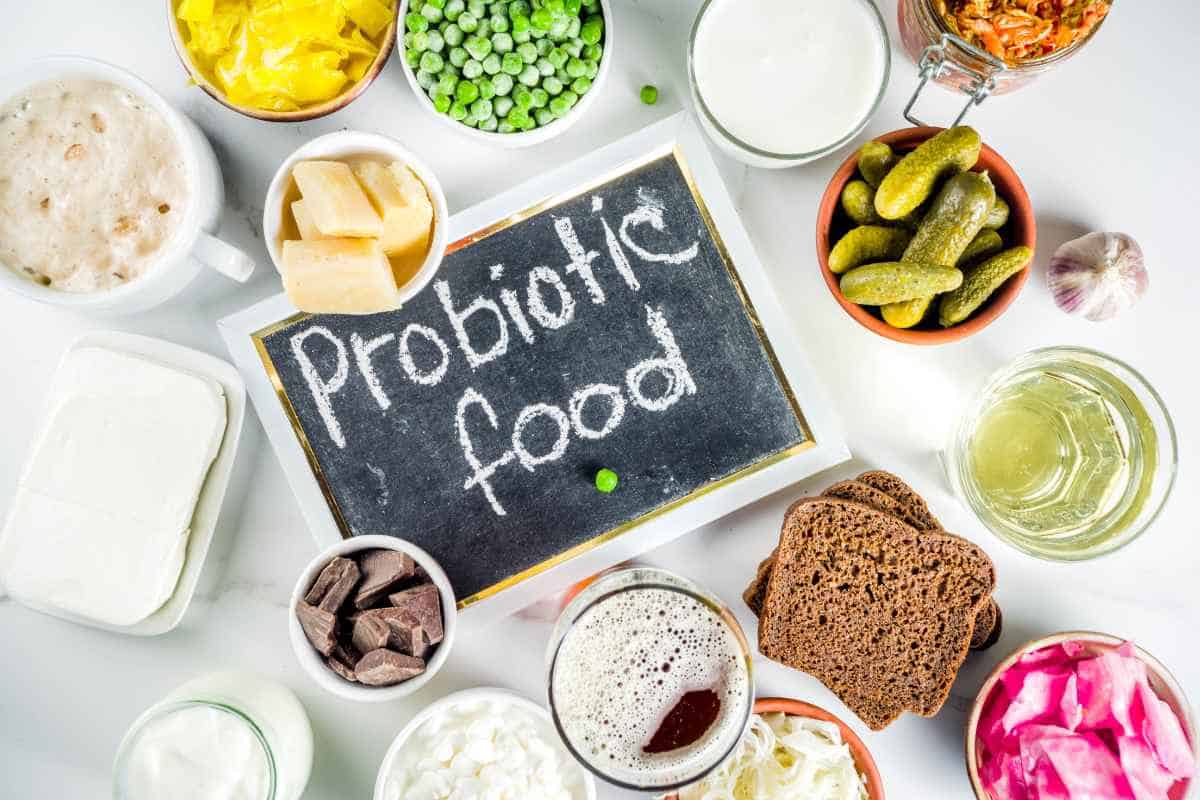A variety of probiotic-rich foods arranged around a chalkboard sign that reads "probiotic food.