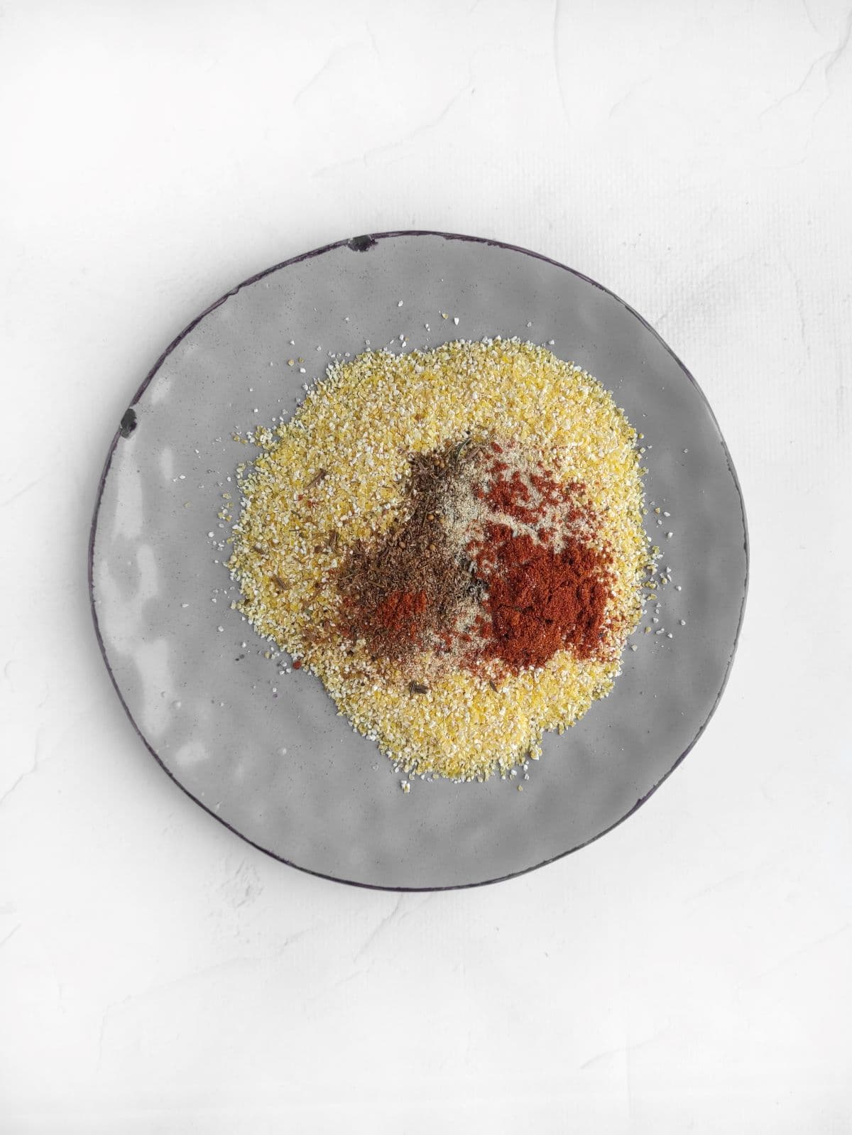 A plate of corn grits, spices, and seasonings,