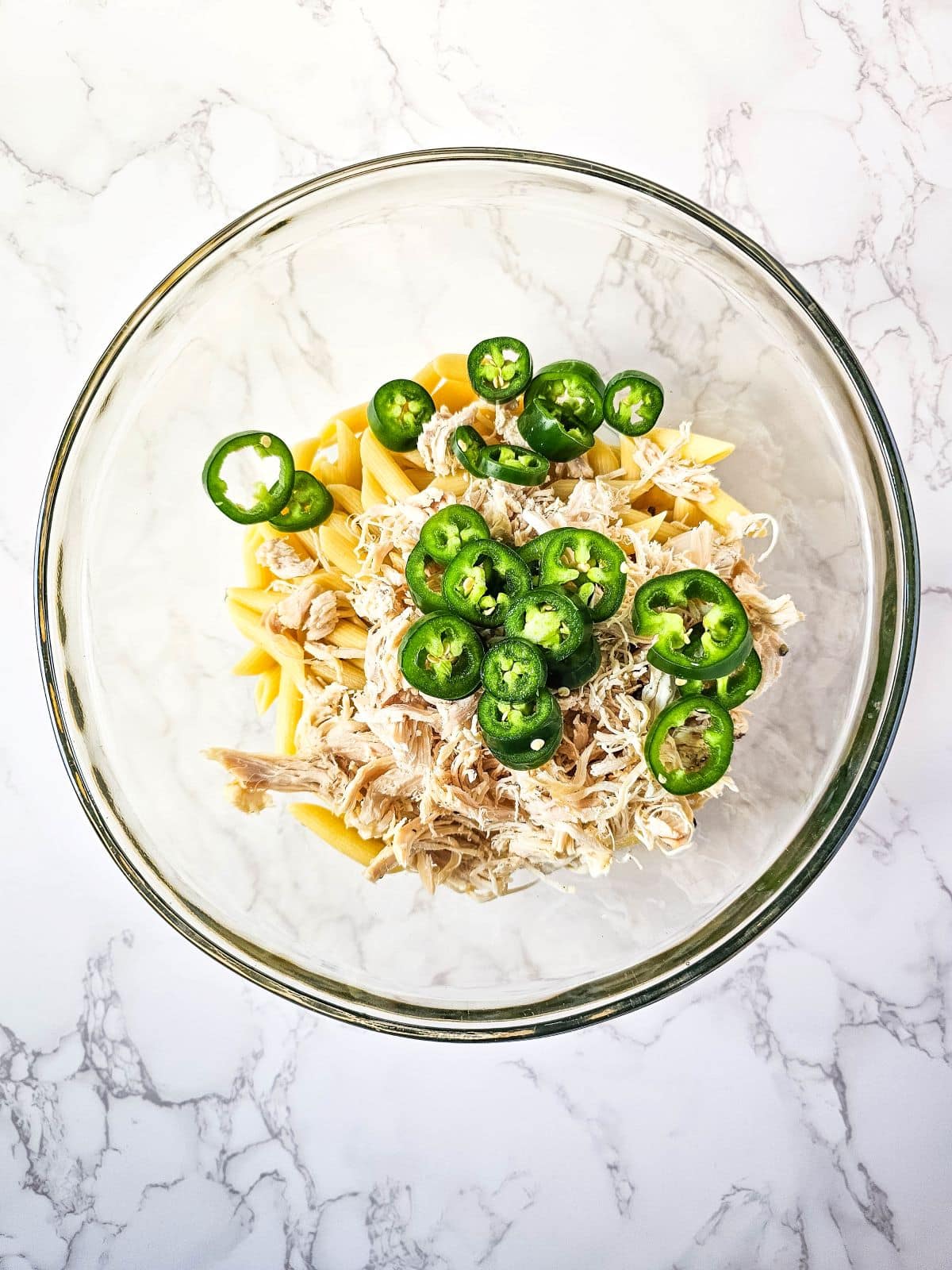 A bowl of jalapeño poppers chicken casserole on a marble surface.