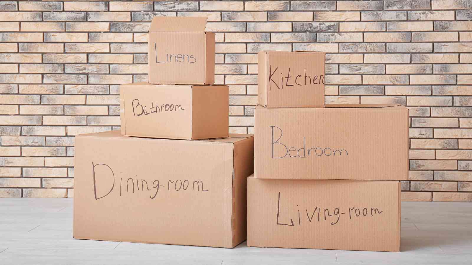 Six labeled boxes are stacked against a brick wall.