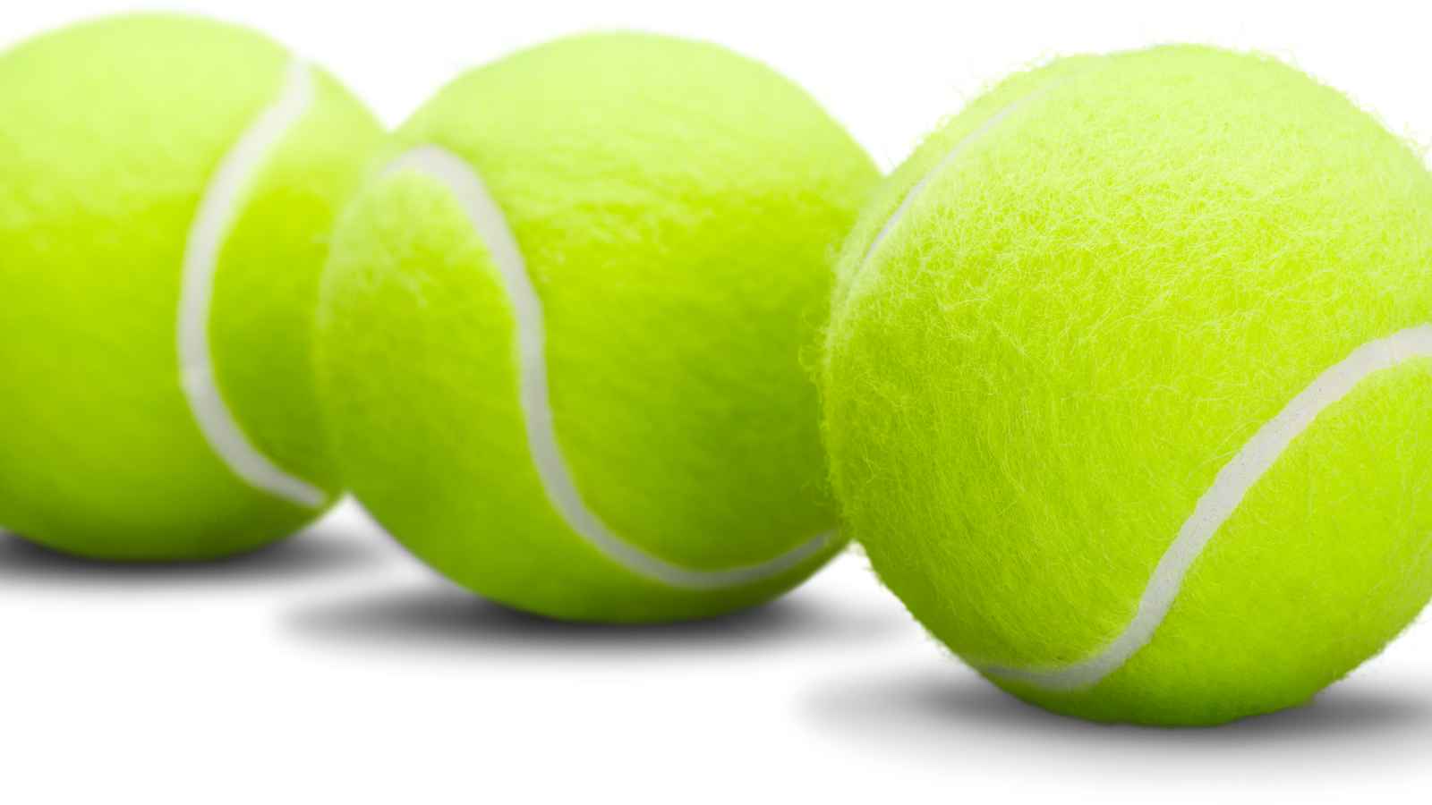 Three yellow tennis balls are aligned in a row on a white background.