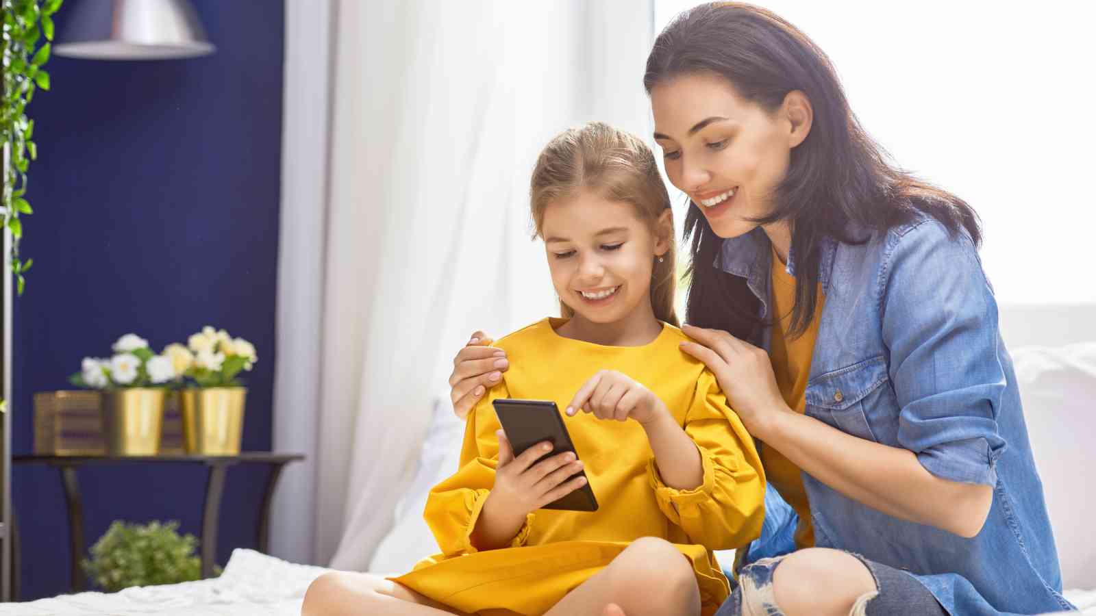 A mother and her daughter watching a video on the phone.