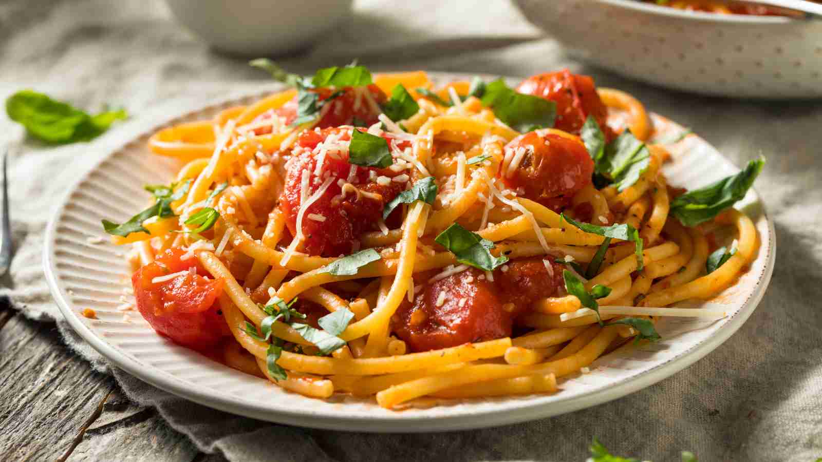 A plate of amatriciana pasta topped with herbs.