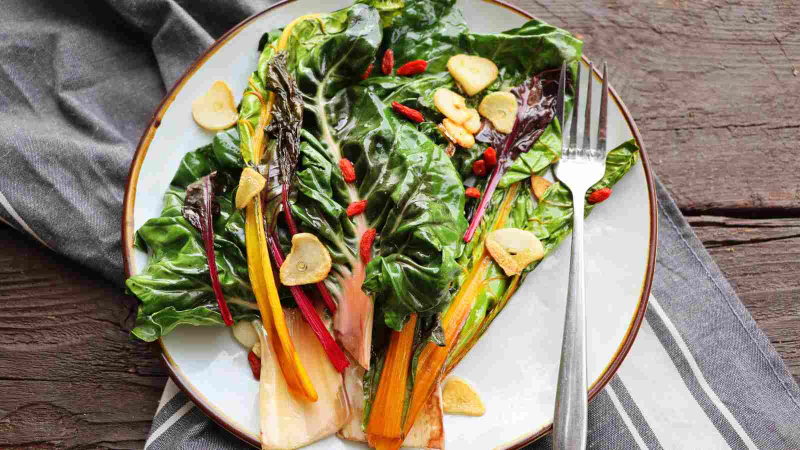 A white plate filled with Swiss chard salad.
