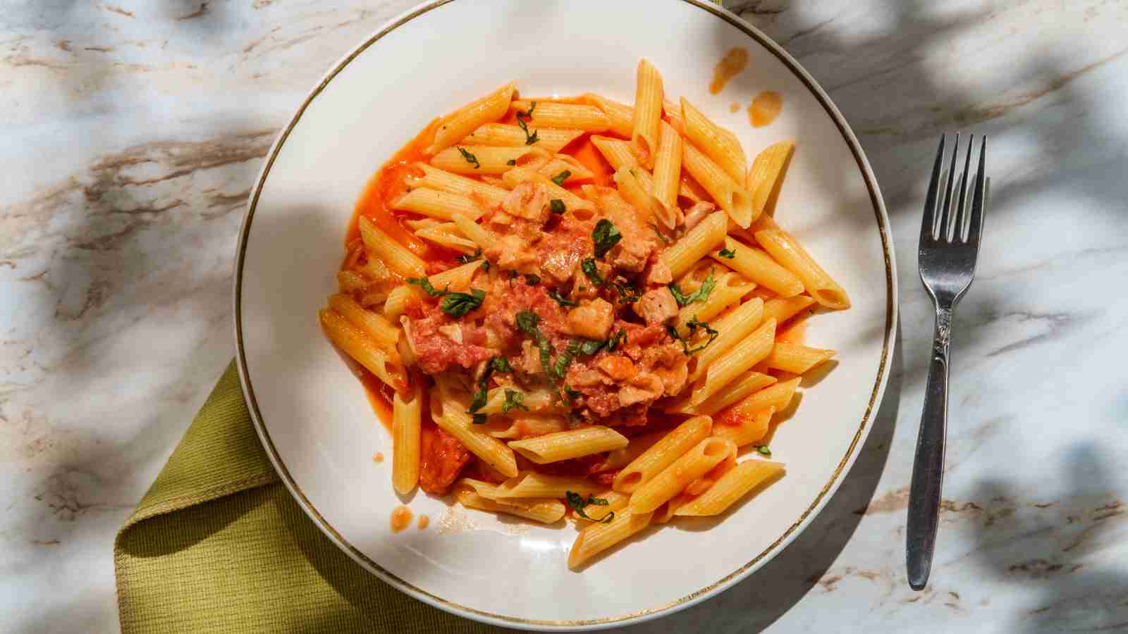 A plate of vodka pasta with a fork on the side.