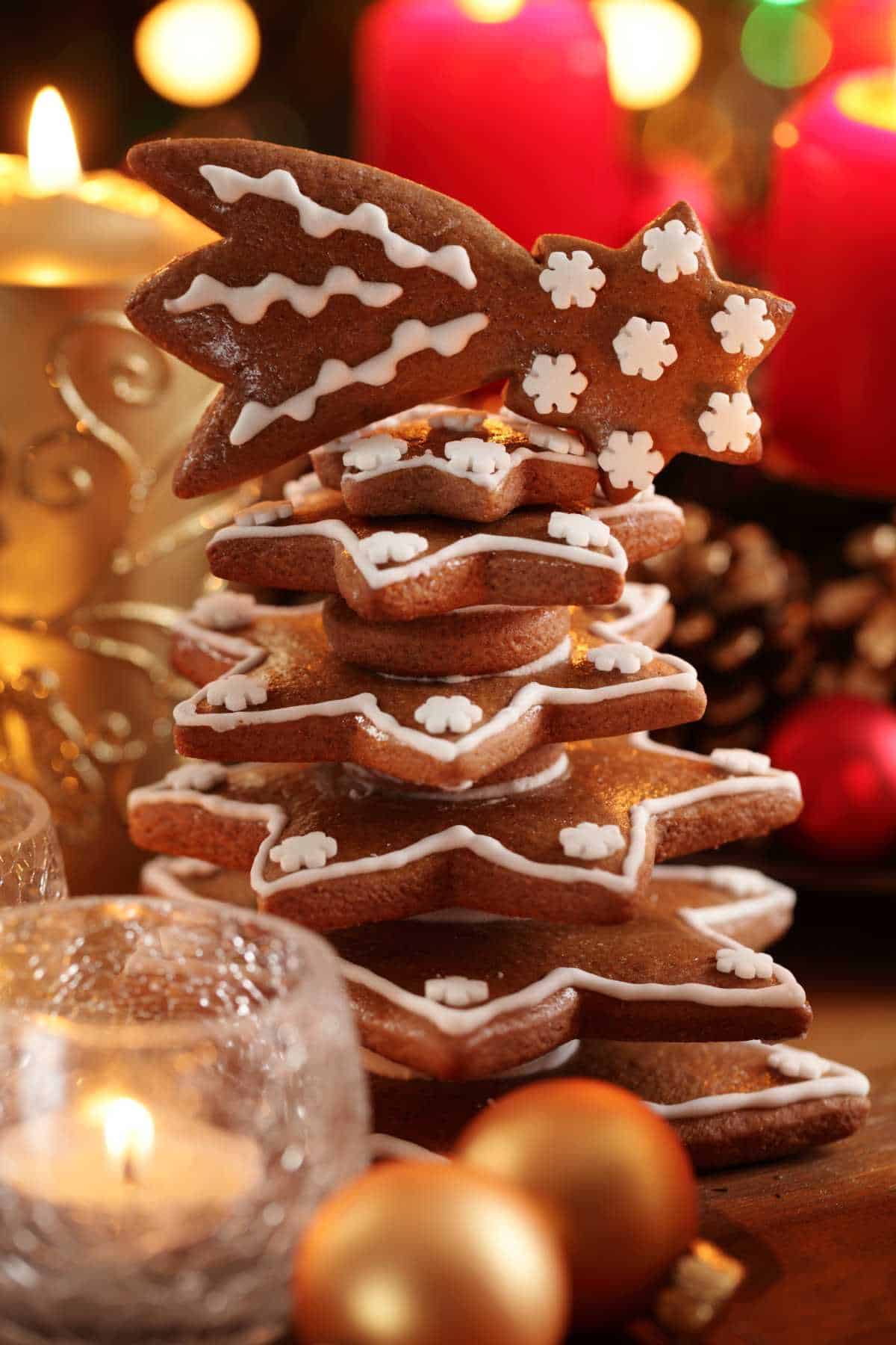 A stack of star-shaped gingerbread cookies with white icing, arranged to resemble a Christmas tree.
