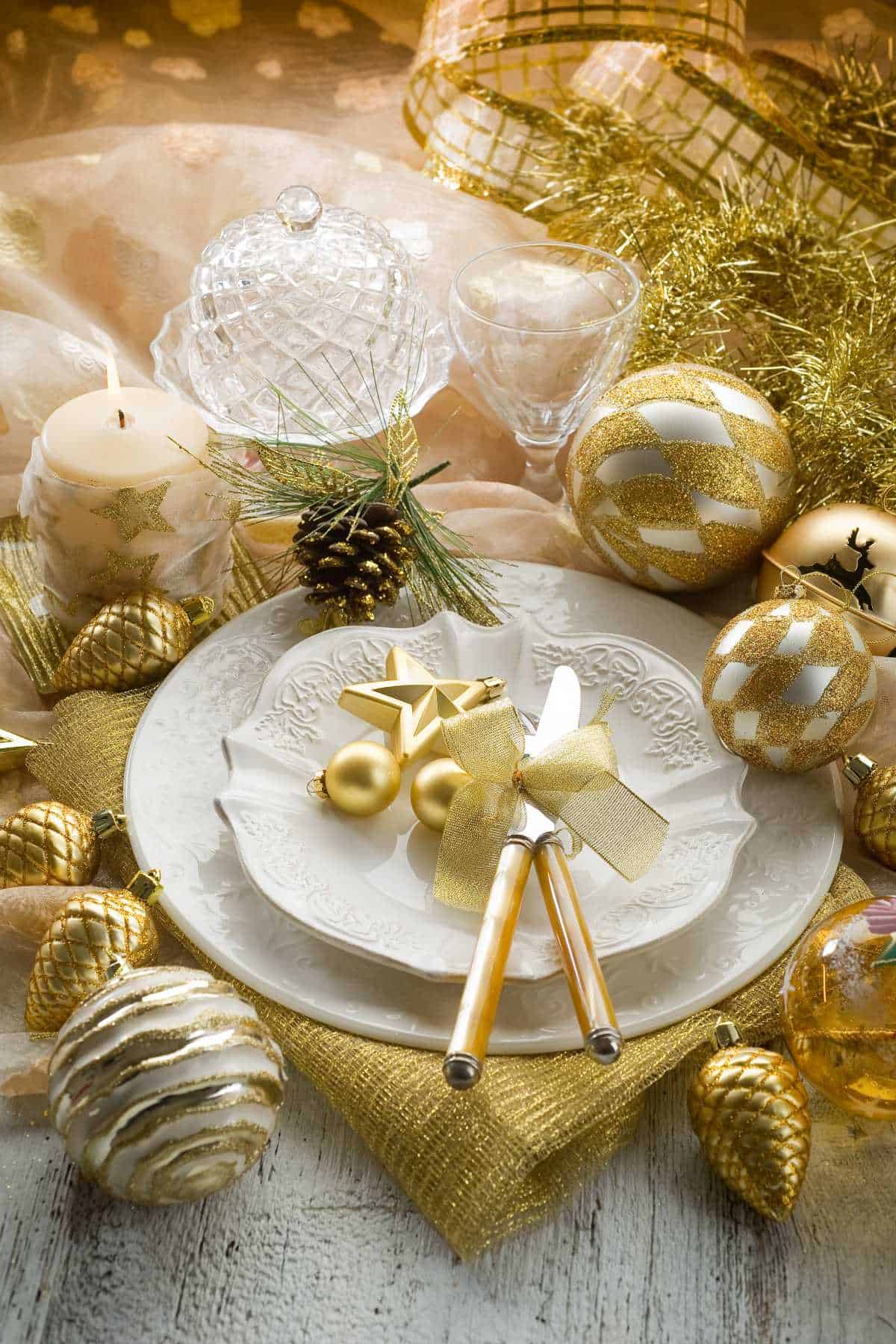 Elegant holiday table setting with white and gold ornaments.