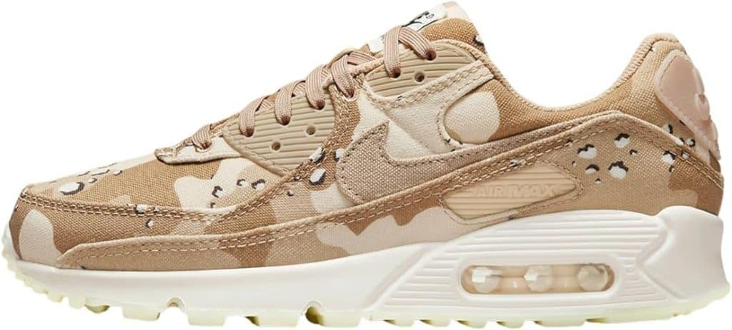 A side view of a tan and beige camouflage-patterned sneaker with white sole and air cushion.