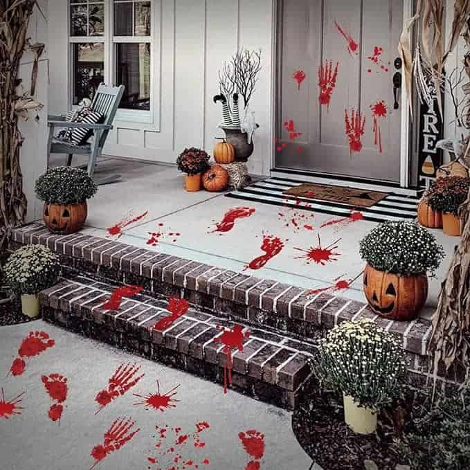 Red handprints and footprints resembling blood are scattered on the door, steps, and walkway.