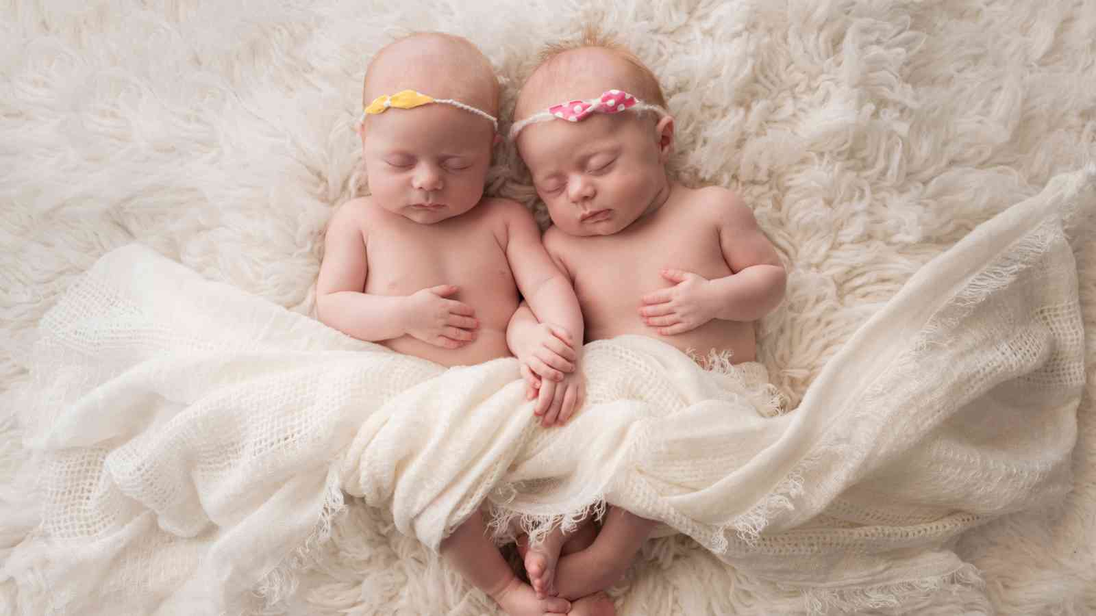 Twin baby girls wearing matching tutu skirt and headband.