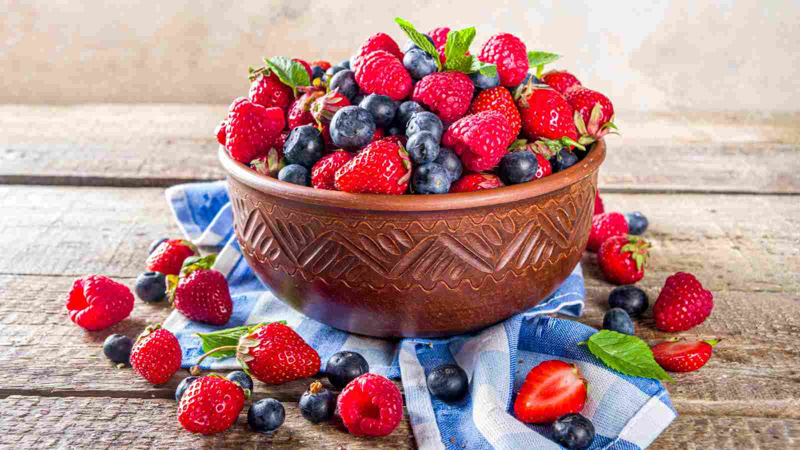 A bowl filled with a variety of berries.