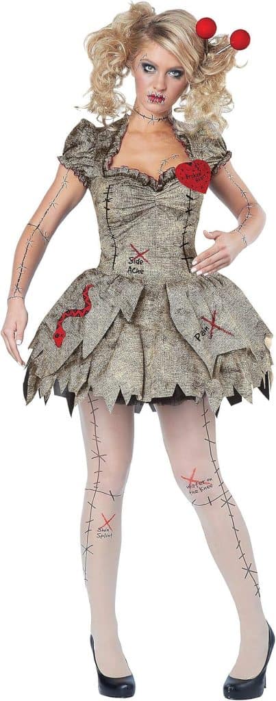 Person in a tattered doll costume with stitched decorations, heart patch, and zigzag hem, standing and holding their arms slightly out to the sides.