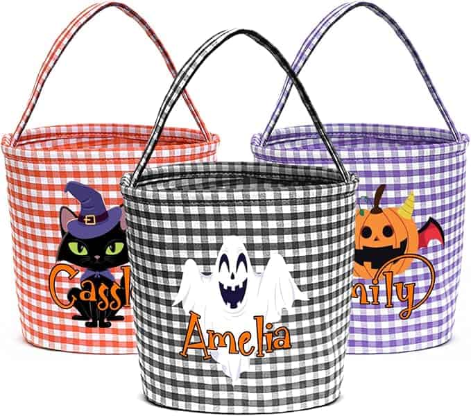Three gingham-patterned Halloween baskets with handles: orange with a black cat, black with a ghost, and purple with a pumpkin.