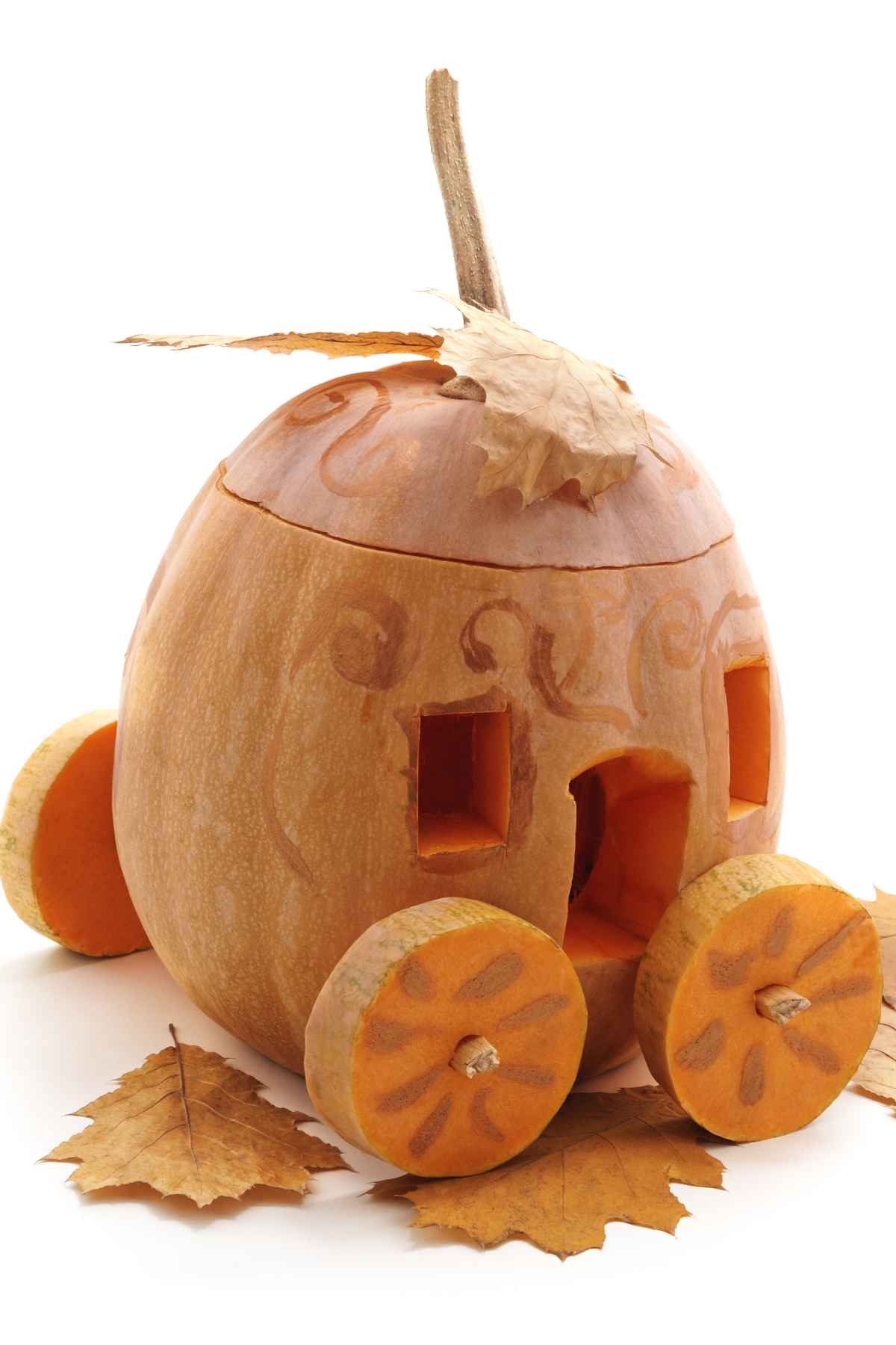 A pumpkin carved and styled to resemble a carriage with leaf decorations and circular wheels.