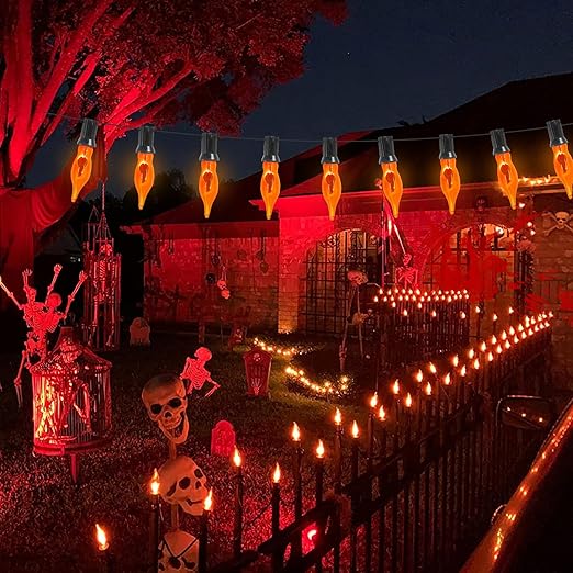 A house decorated for Halloween with red lights, skulls, and pumpkins.