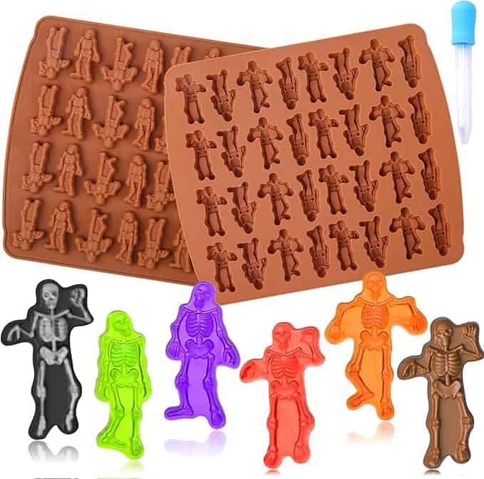 Silicone molds with skeleton designs and colorful skeleton-shaped gummies, along with a small blue dropper.
