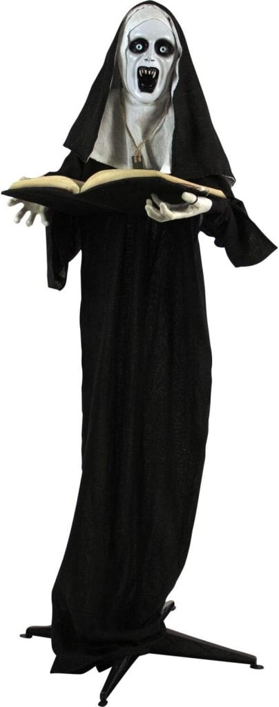A life-sized Halloween decoration of a spooky nun holding an open book, dressed in black with a white, menacing mask.